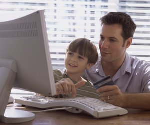 Father and his son sitting in front of a computer