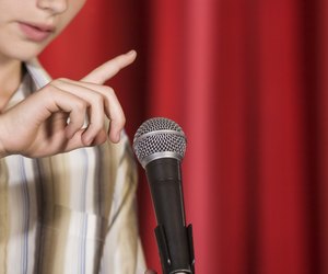 Boy on stage tapping microphone