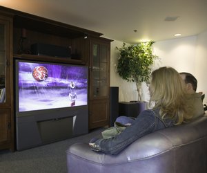 Couple watching widescreen TV set in bookcase