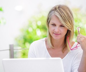 smiling woman working on a computer on her garden