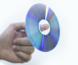 Holding a disc with finger white bckground