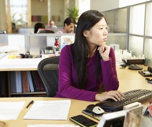 Asian Woman Working At Computer In Modern Office