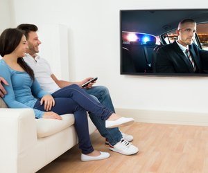Happy Couple In Livingroom Watching Movie