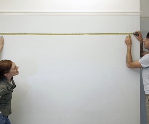 Couple measuring and marking a wall