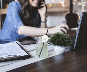 Beautiful hipster woman using laptop at modern office