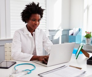 Black female doctor wearing white coat at work in