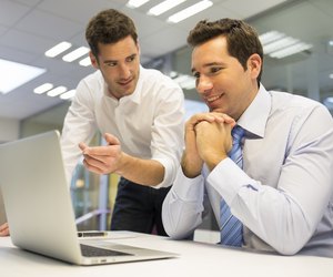 Two handsome businessmen working together on a project at office