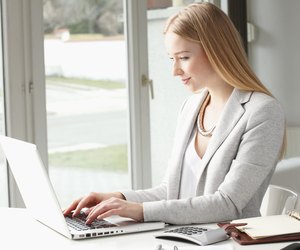 Attractive business woman is typing on her keyboard