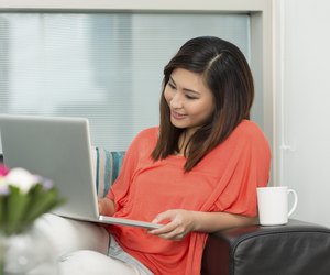 Asian woman at home working on a laptop