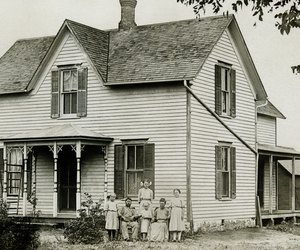Family standing in front of house