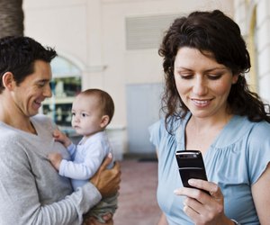 Parents with baby and mother with cell phone