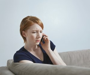 Woman talking on mobile phone on sofa