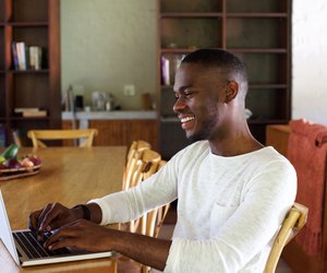 Young african man working on laptop indoors