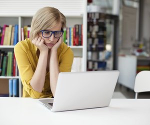 Overworked sad woman working in library