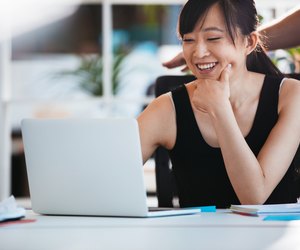 Smiling woman working on laptop at office