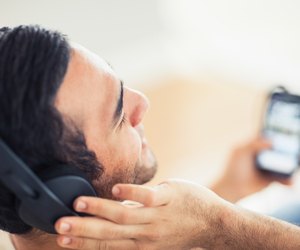 Close up on handsome man listening to music on his smartphone