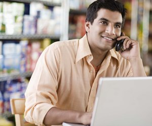Man on cell phone with laptop