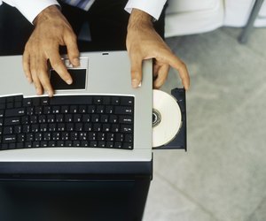 High angle view of a businessman inserting a cd into a laptop