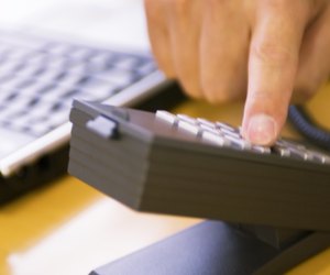 Businessman dialling number on telephone