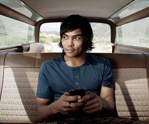 Young man inside car using smartphone