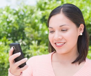 Woman outdoors holding cell phone