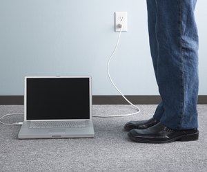 Adult standing beside laptop computer