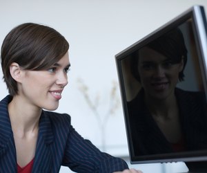 Businesswoman staring at reflection on computer screen
