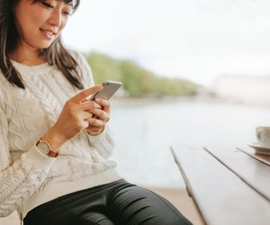 Attractive young female using cellphone at cafe