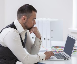 Young businessman using at laptop at desk