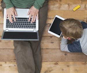 Mother and son using tablet and laptop