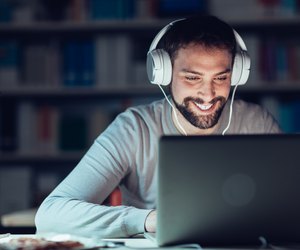 Smiling man networking late at night