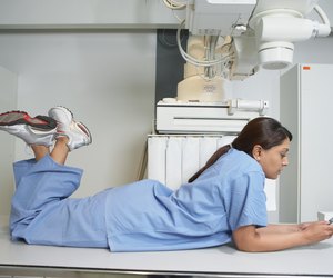 Indian female nurse laying on table using cell phone