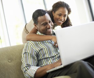 Affectionate Couple Using Laptop in Living Room