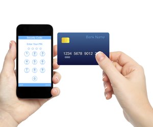 female hands holding phone and credit card