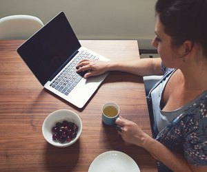 Horizontal overhead view of woman working on computer at home