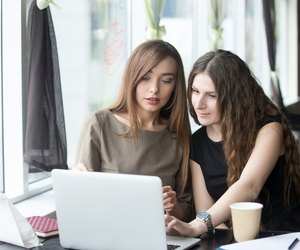 Two young beautiful women chatting in cafe