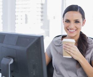 Attractive businesswoman drinking coffee and cheering