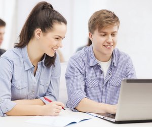 students with laptop and notebooks at school