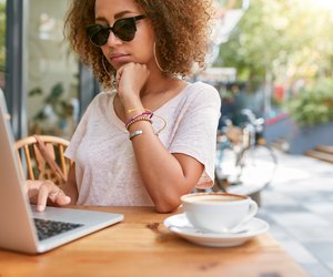Woman at sidewalk cafe reading emails