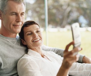 Mature Couple Sit Together Looking at a Mobile Phone