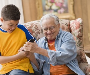 Young boy and his grandfather fighting over the remote control