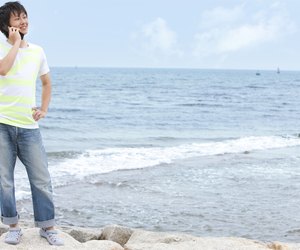 Young man using mobile phone at beach