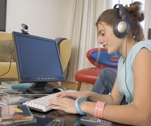 Young woman wearing headphones and using computer