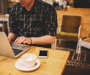 Young man sitting in a coffee shop using laptop