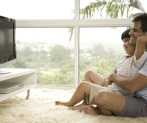 Side profile of mature man with his son (8-9) watching television