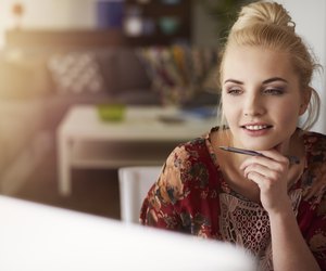 Young creative woman working at home