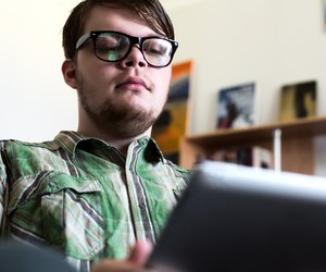 Portrait of Young Man using Tablet Computer in Home Interior