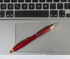 Ballpoint Pen Lying On Laptop
