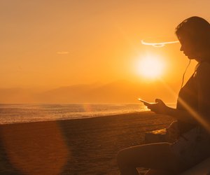 Young woman listen music on the beach