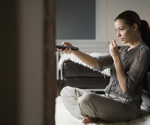 Cheerful young woman using a remote control